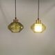 Hanging lamp with an outer shade of olive green glass and an inner shade of clear, crystal glass.