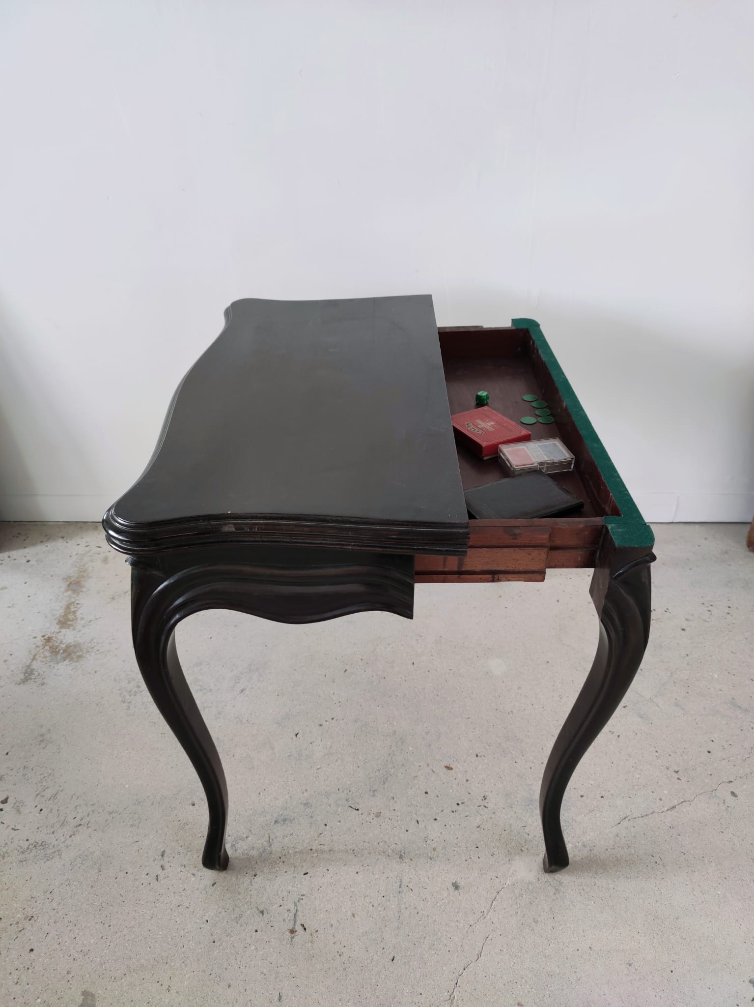 Molded blackened wooden play table, arched legs, green felt