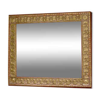 Large beveled mirror with its golden frame.