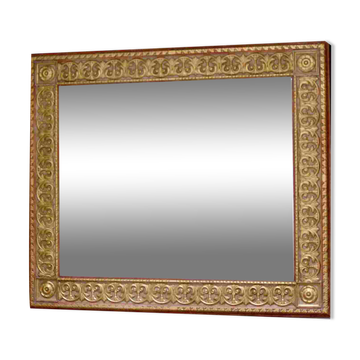 Large beveled mirror with its golden frame.