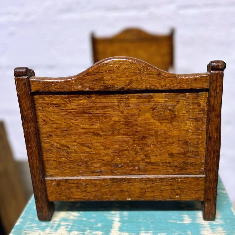 Old doll's bed in varnished wood