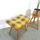Vintage footrest with checkered cushion