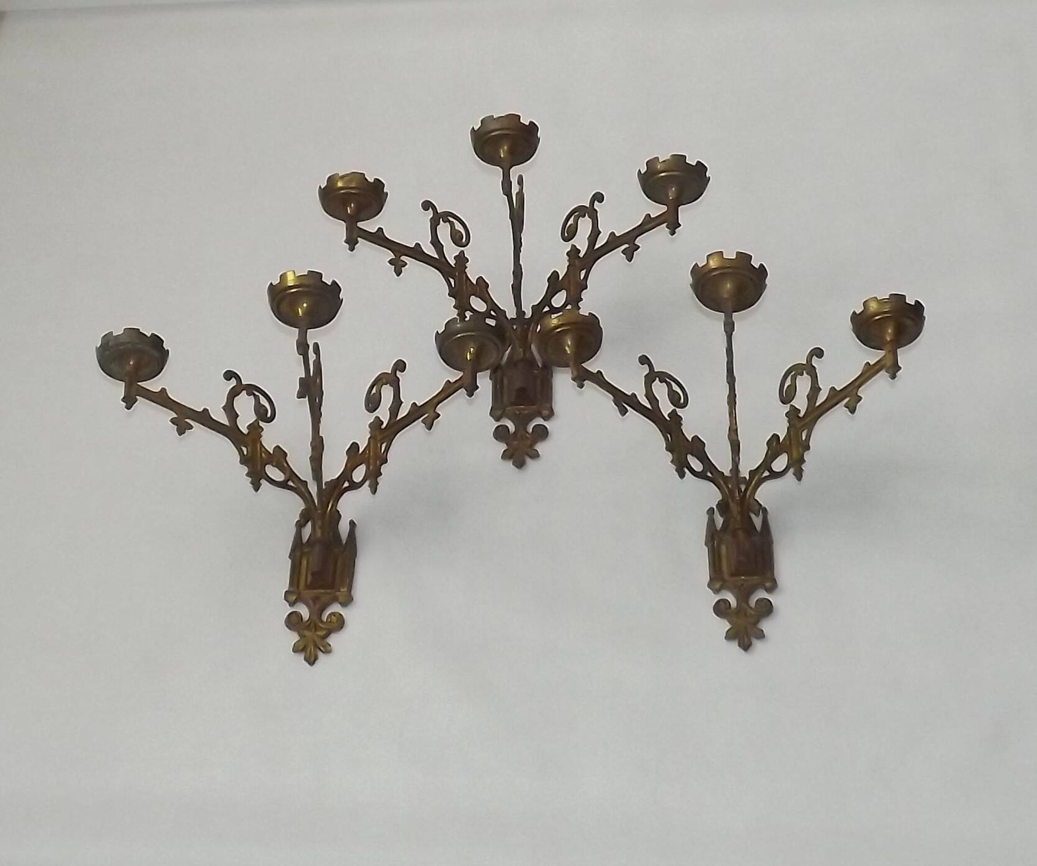 Ensemble élégant de trois appliques murales en bronze doré de style gothique français.