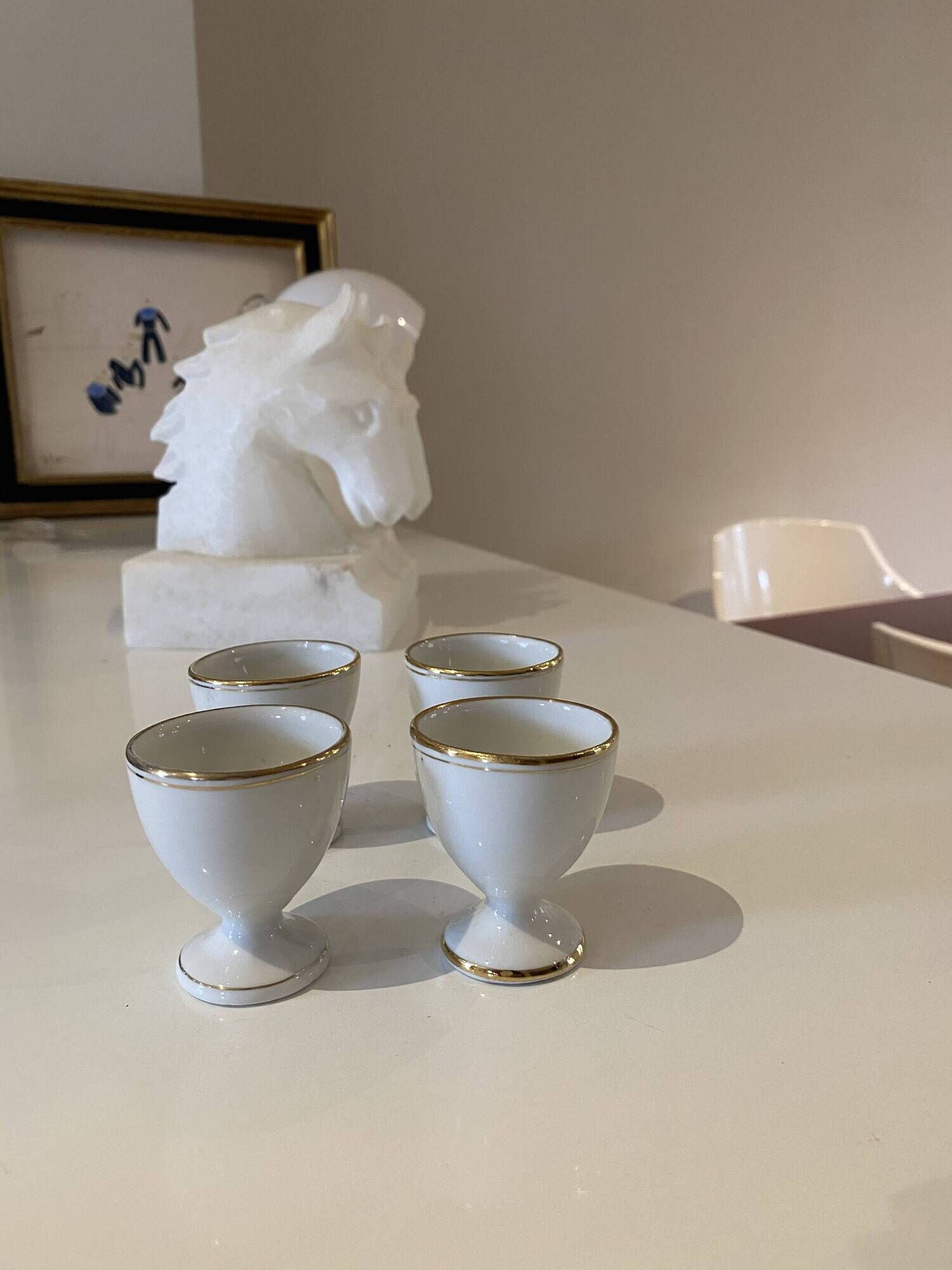 Set of 4 vintage egg cups in white porcelain with a gold rim.