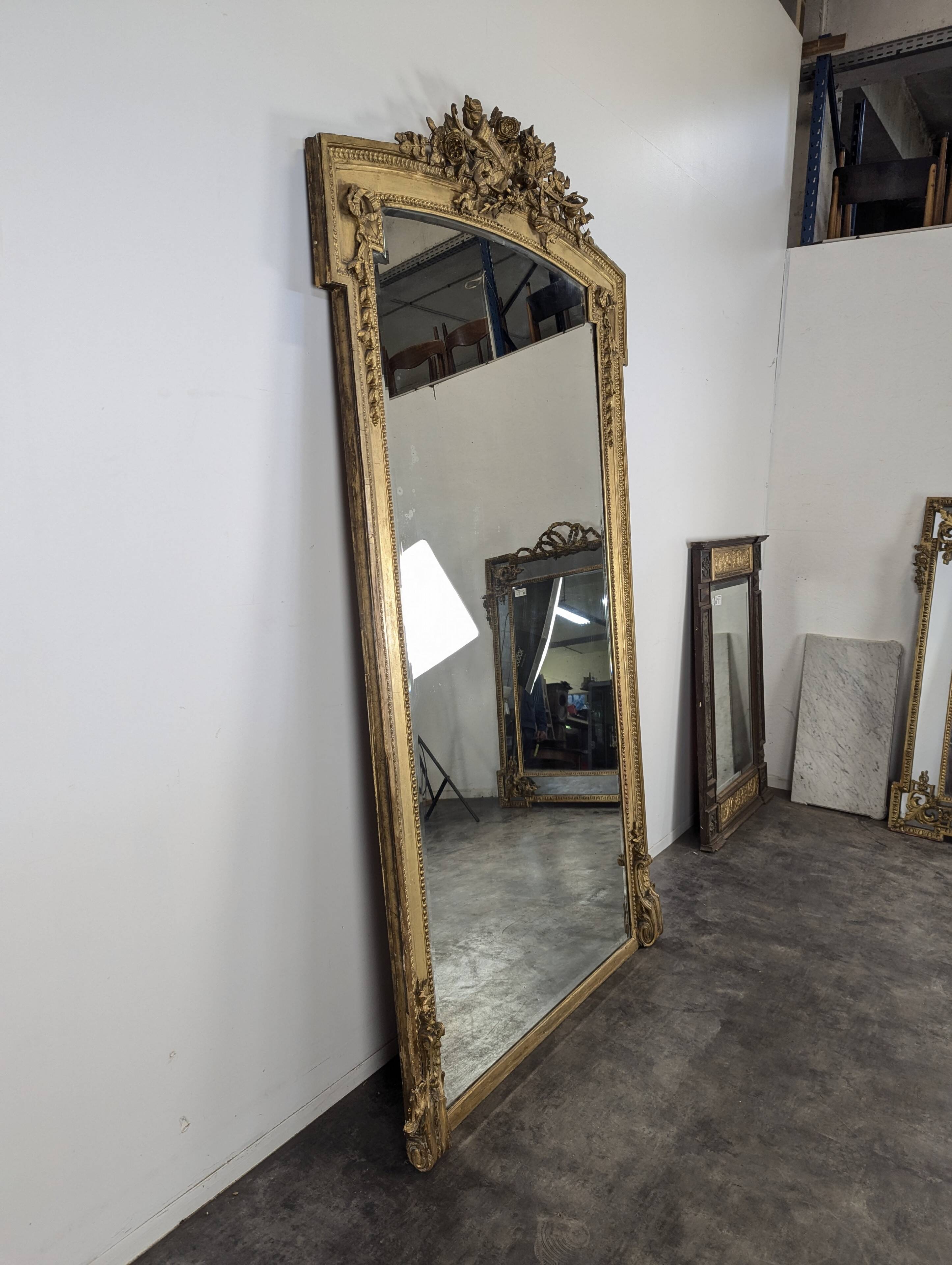 Large gilded wooden mirror in Louis XVI style from the late 19th century.