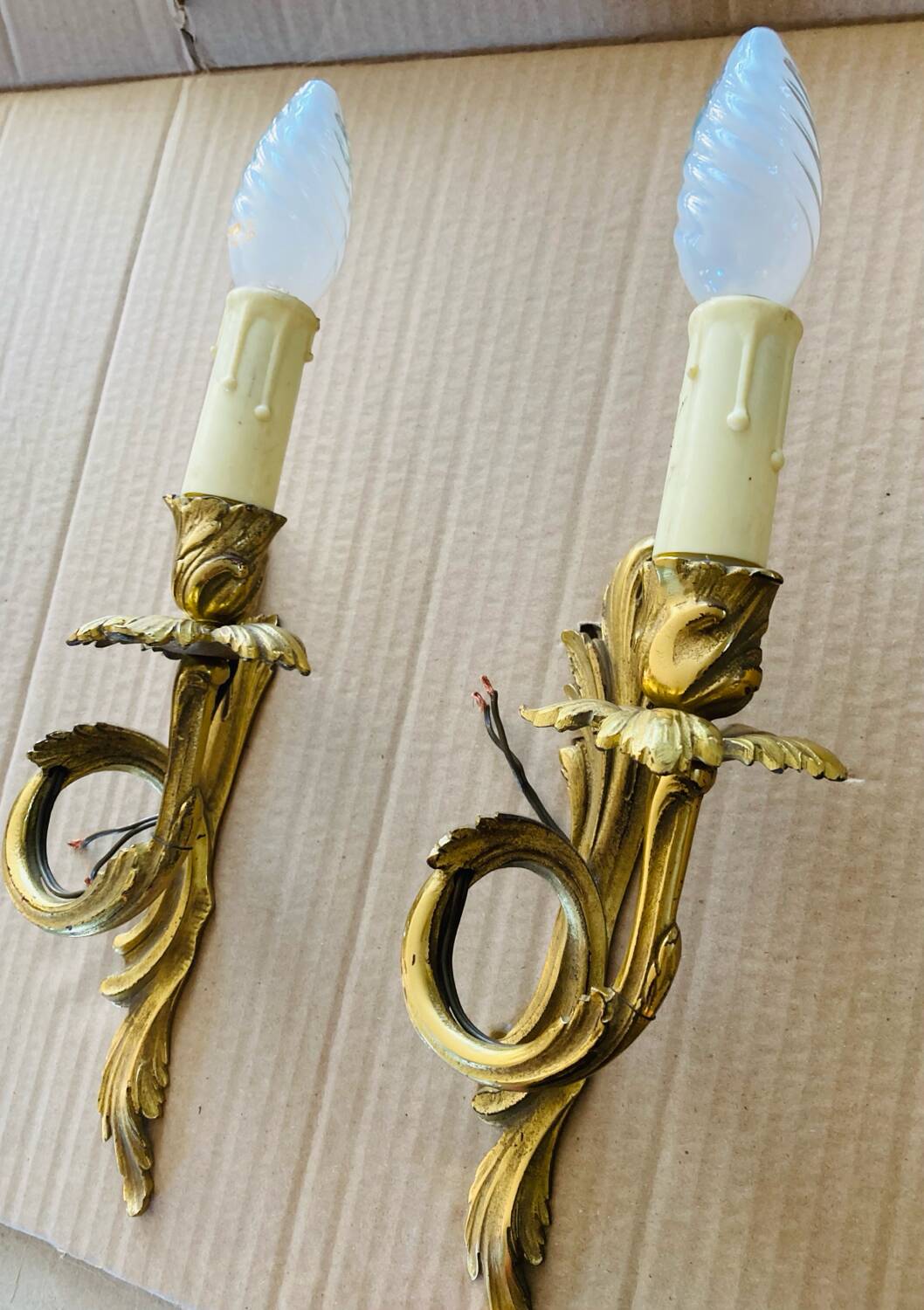 Bronze wall lights in the Louis XV style with curved branches and leaf decorations.