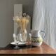 Large white terracotta carafe with a stylized green and yellow frieze pattern