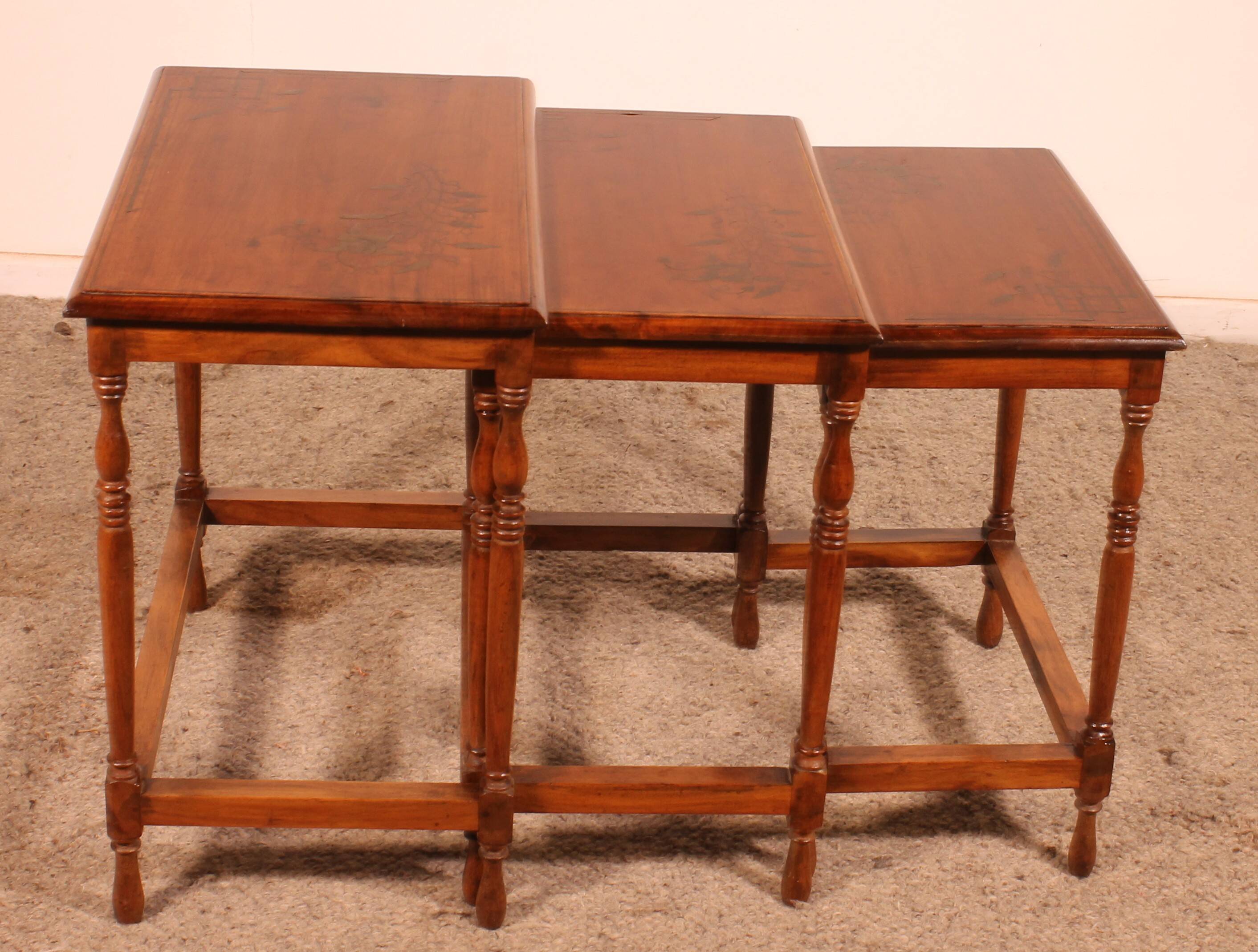 Nested tables in satin wood with brass inlays.