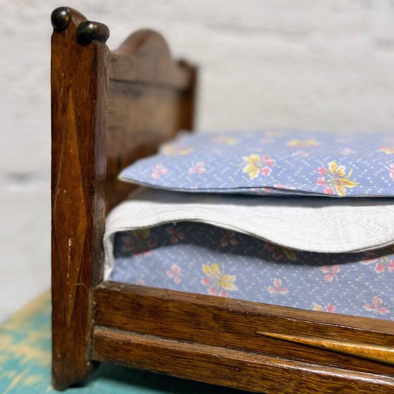 Old doll's bed in varnished wood