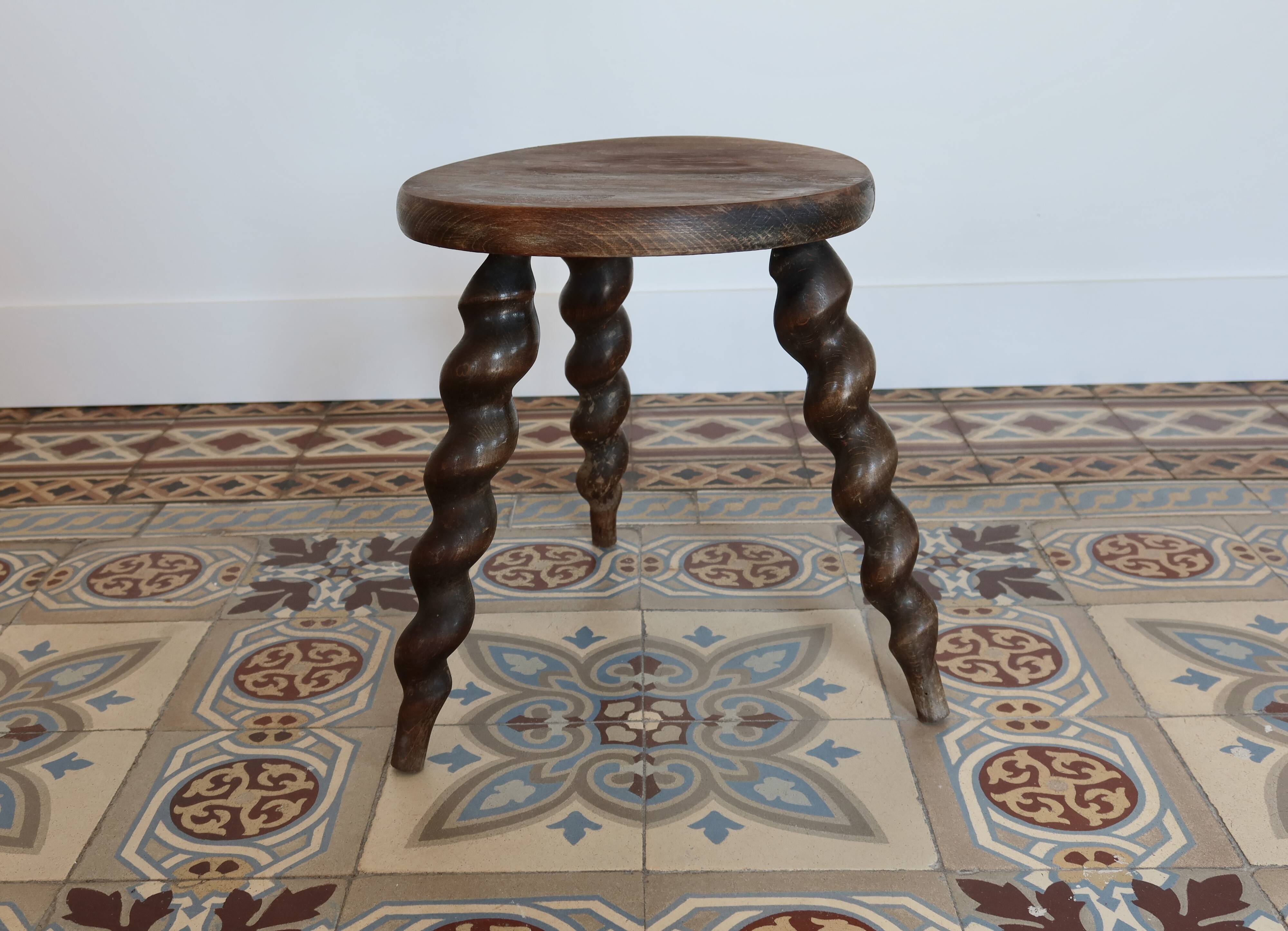 Antique tripod stool made of turned wood.