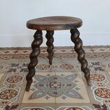 Antique tripod stool made of turned wood.