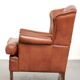 Light cognac-coloured cow leather wingback armchair with matching piping