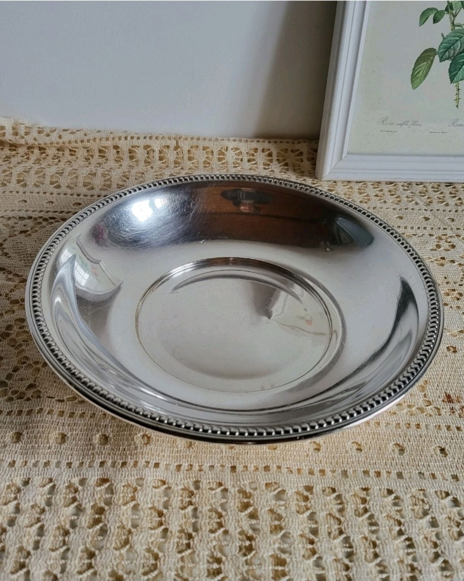 Shallow round metal plate with pearl row decoration.