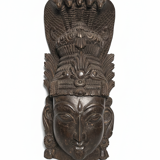 Ancient Indian carved wooden mask sculpture of a deity with a cobra.