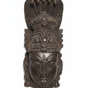 Ancient Indian carved wooden mask sculpture of a deity with a cobra.