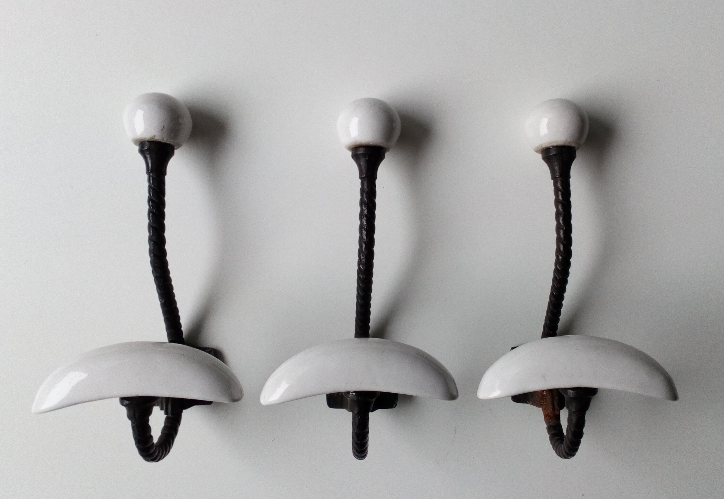 Trois patères doubles en fer forgé et porcelaine