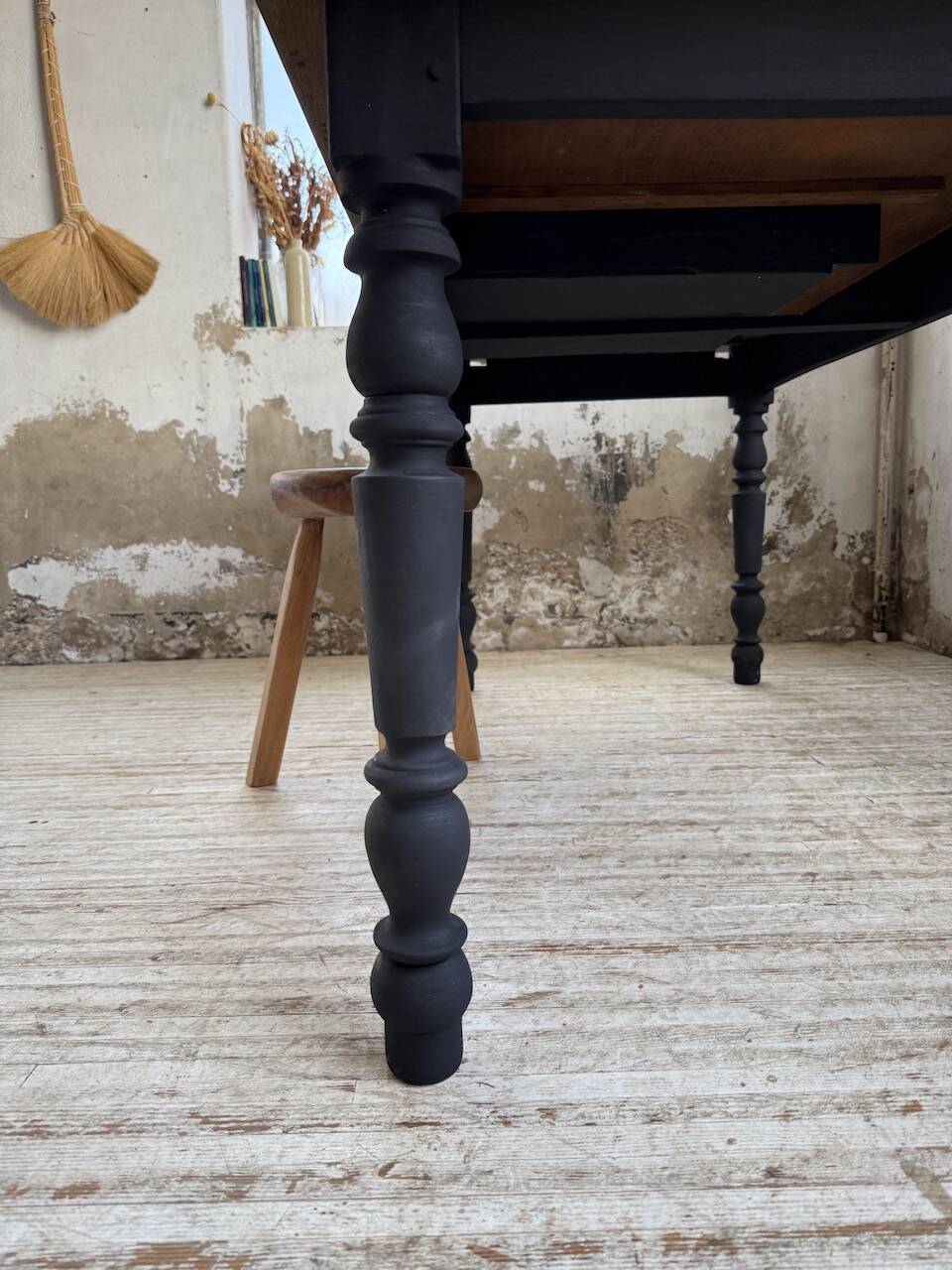 Oak farmhouse table with turned black legs.
