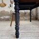 Oak farmhouse table with turned black legs.