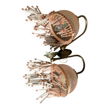 Pair of wall sconces in pink glass with pendants.