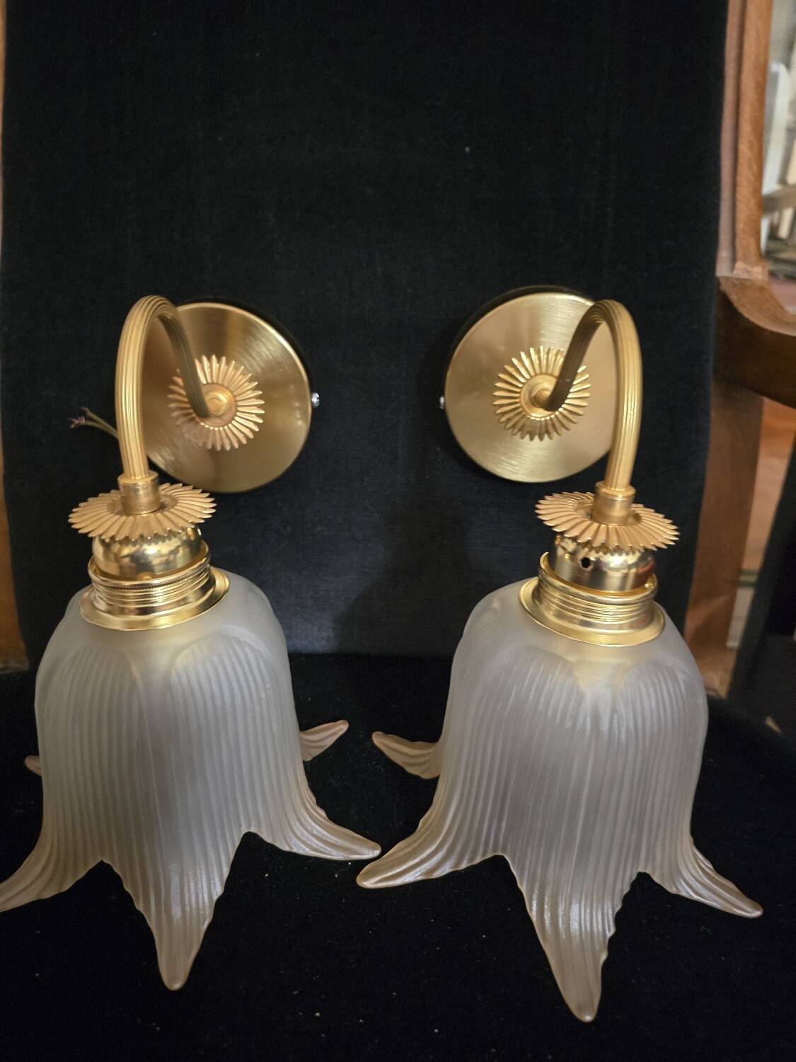 Frosted glass wall sconces and gilded brass in Art Deco style.