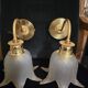 Frosted glass wall sconces and gilded brass in Art Deco style.