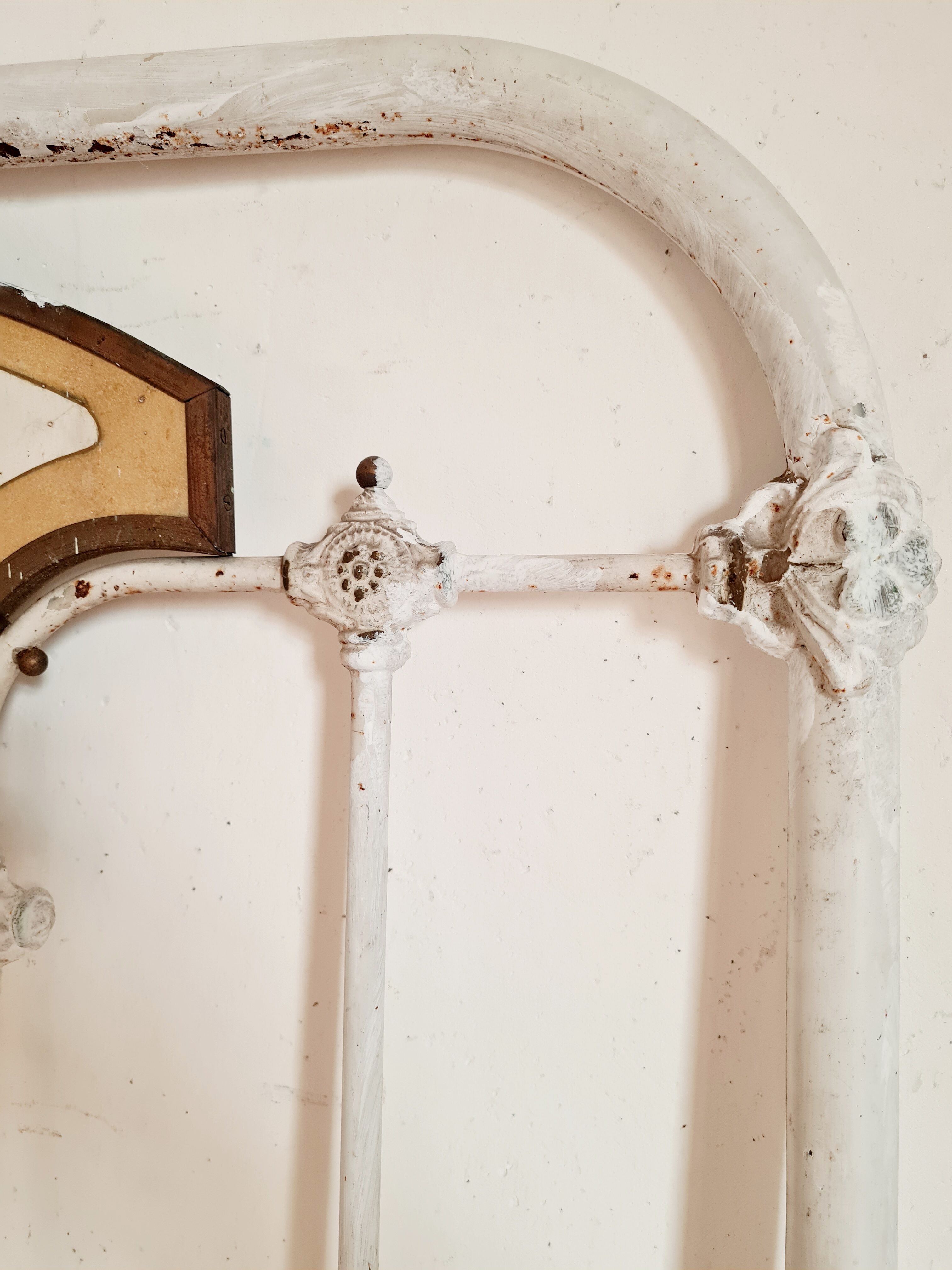 Cast-iron headboard and patinated white wood