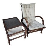 Relaxed armchair in bamboo and rattan with its small side table. Beige linen cushion.