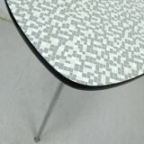 Table basse des années 1950 à trois pieds avec un plateau en formica et des pieds en chrome inclinés.