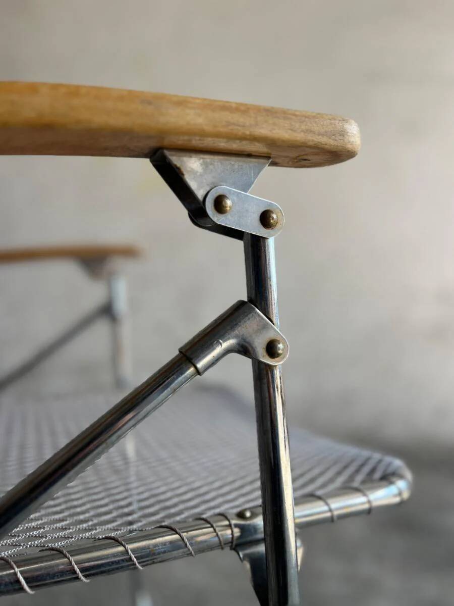 Pair of vintage silver aluminum wire folding chairs with wooden armrests — industrial minimalist