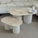 Oval coffee table duo travertine and white fluted wooden legs.