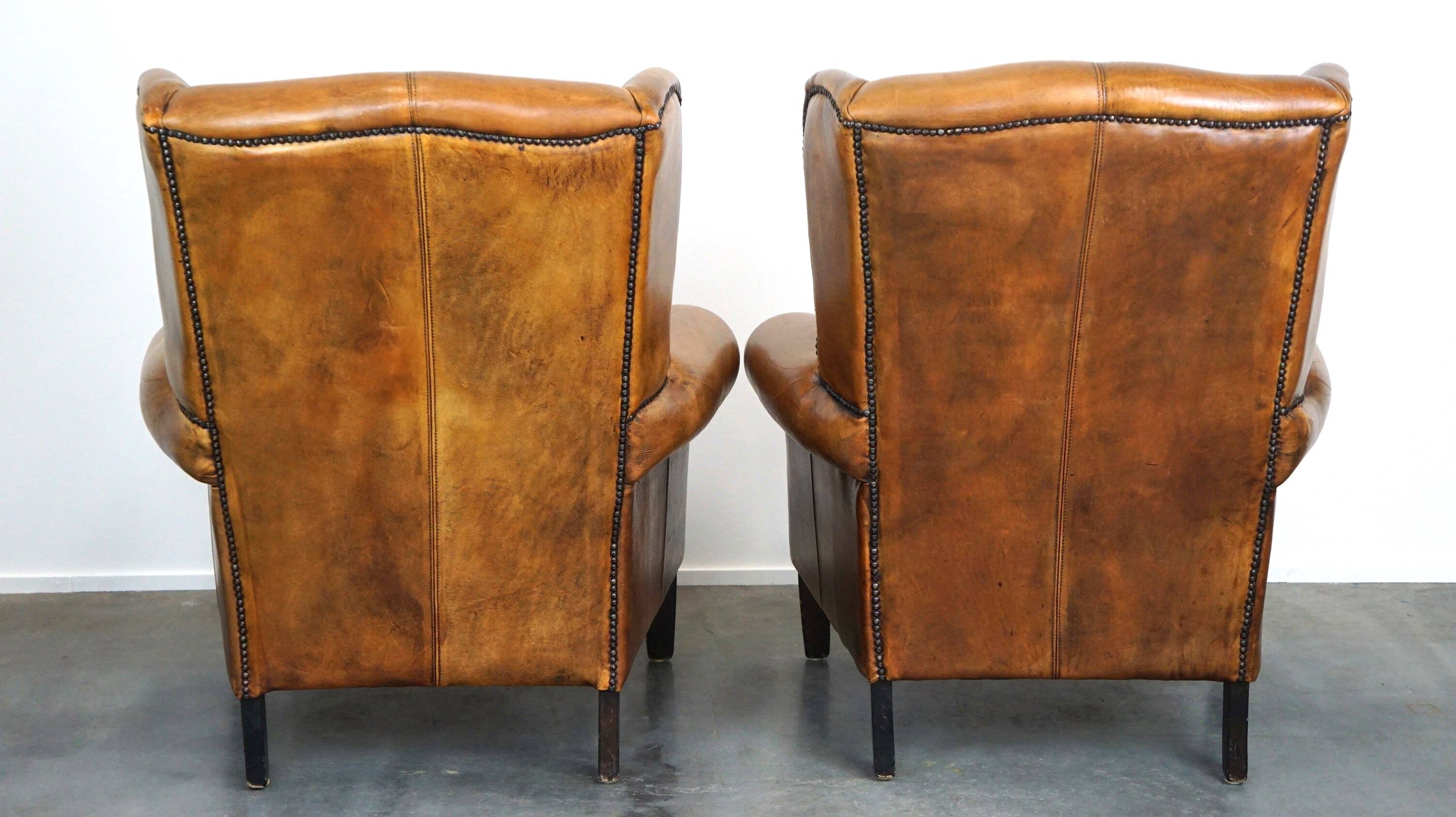 Set of 2 beautiful and correct sheep leather wingback armchairs with fixed seat cushions