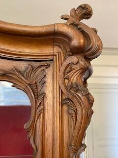 Large wooden display cabinet in Louis XV/rococo style with a strongly curved front.