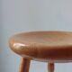 Vintage en bois tourné tabouret du milieu du siècle avec un siège épais.