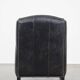 Black cow leather armchair in industrial style finished with decorative nails