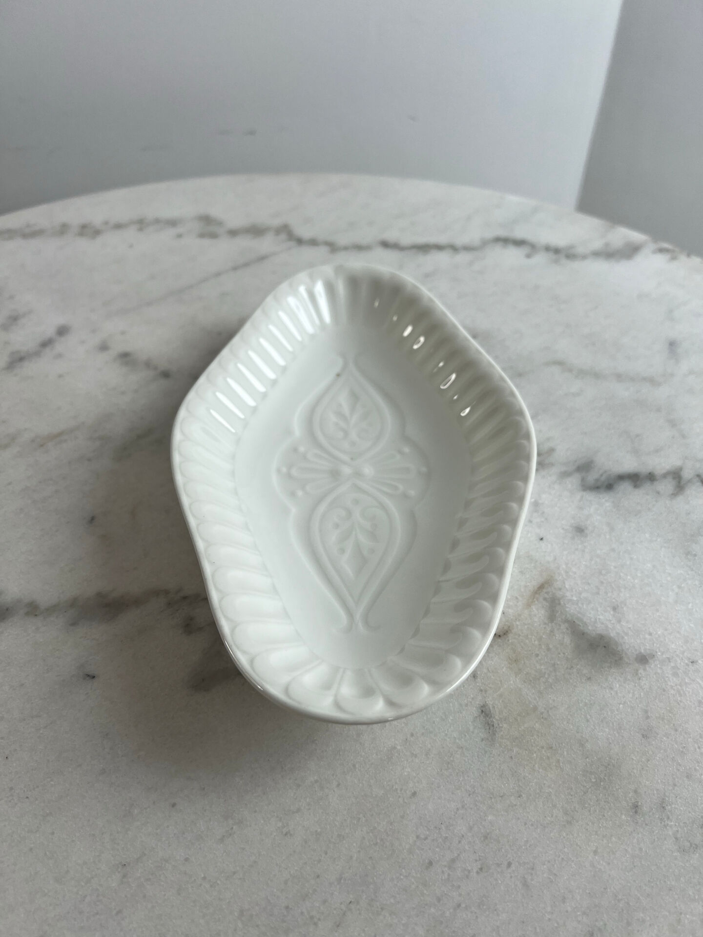 Oval white porcelain ramekin — raised floral pattern