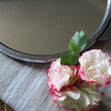 A large round mirror tray with metal handles