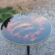 Vintage coffee table with glass top and tripod legs in blackened wood from the 1960s.