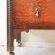 Antique oak chest of drawers on castors with brass handles and carved details