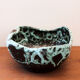 Empty pocket in black ceramic with green drip