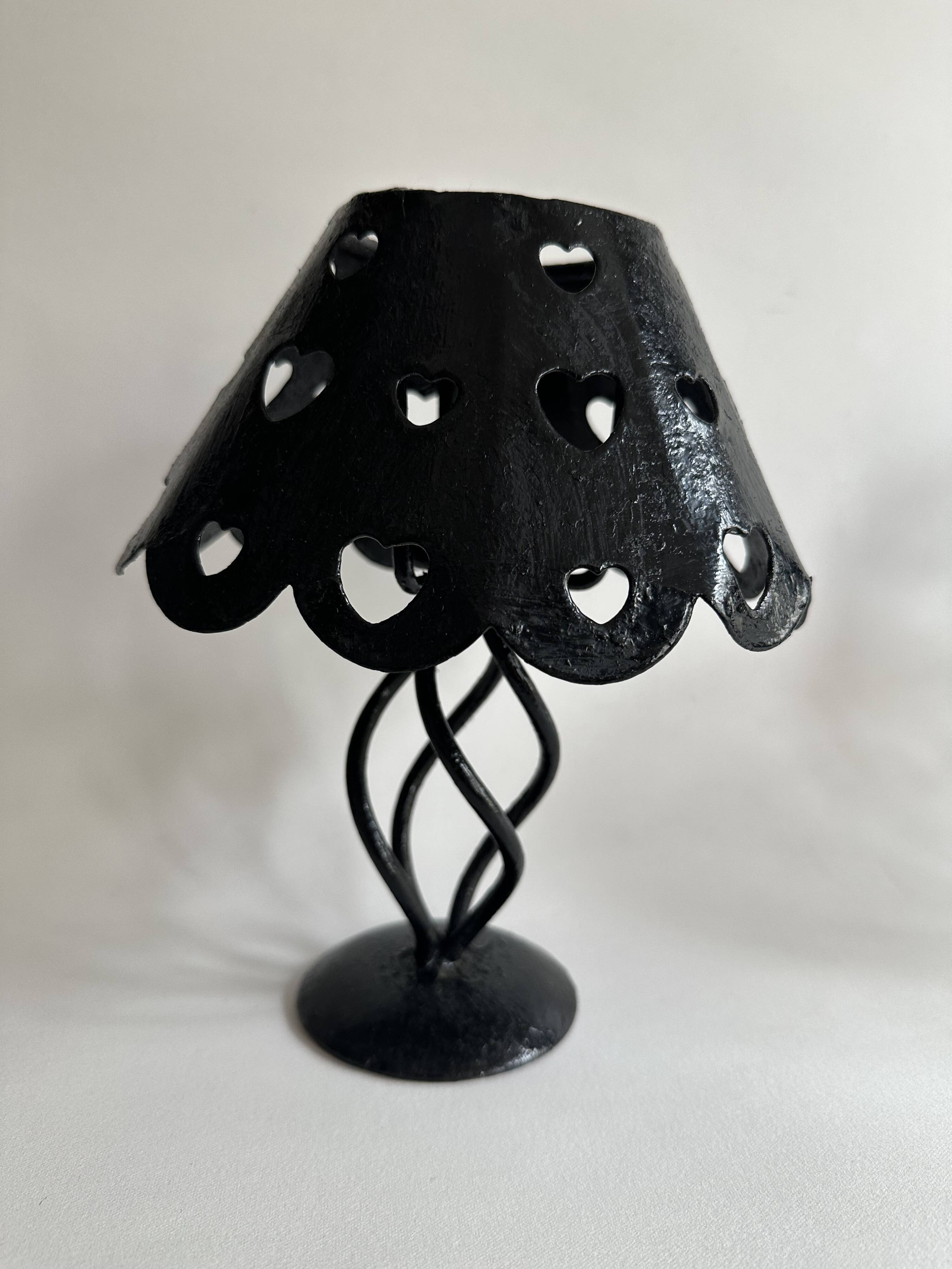Pair of black wrought iron lanterns with heart patterns, romantic style.