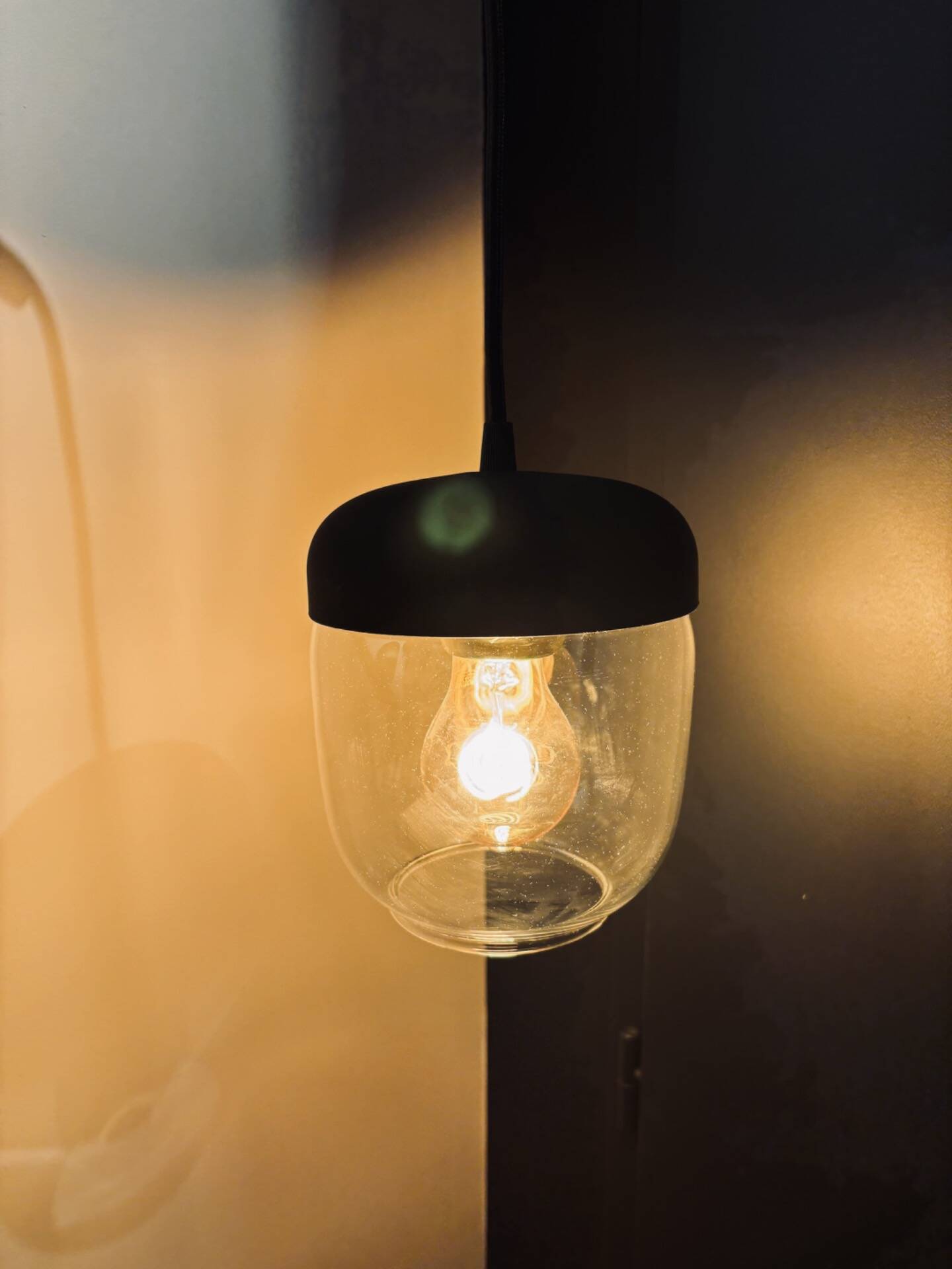 Portable lamp with transparent glass and black plastic.
