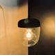 Portable lamp with transparent glass and black plastic.