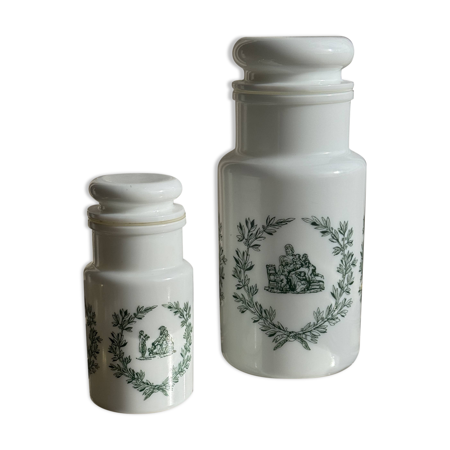 A pair of white glass bottles with Italian green patterns.