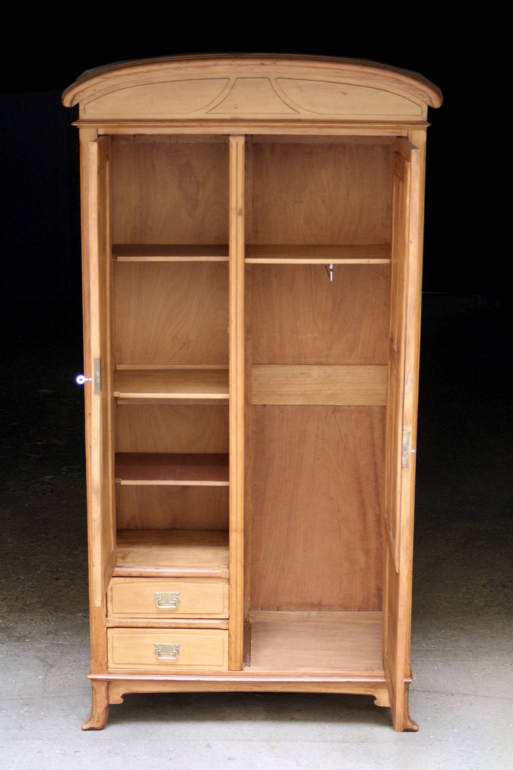 Art Nouveau wardrobe in blond wood with beveled mirror (circa 1909).