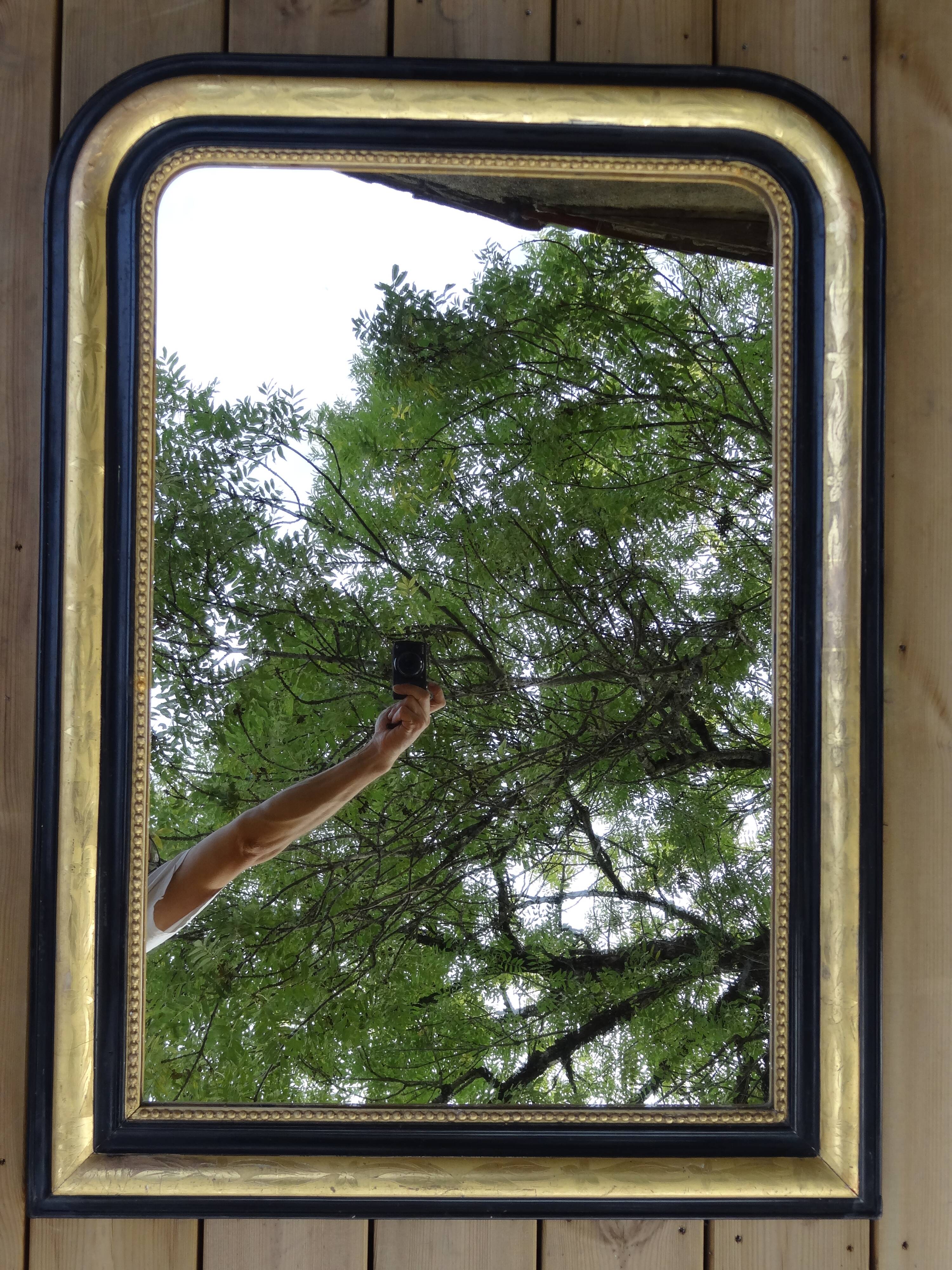 Louis Philippe mirror in blackened and gilded wood, 74 x 102 cm
