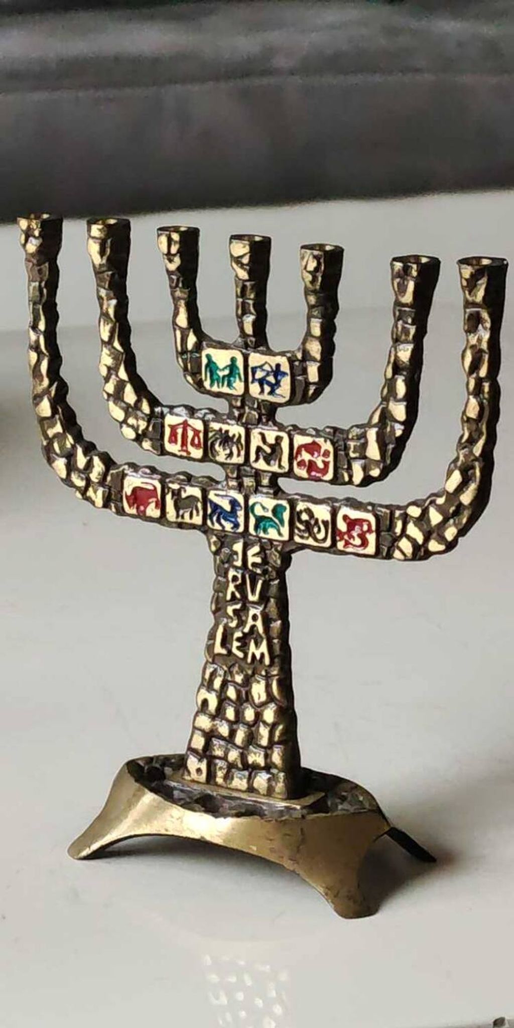 Menorah/Candlestick with 7 light arms. In old gold patinated brass/Decor 12 astrological signs. Engraved Jerusalem. Height 14 cm