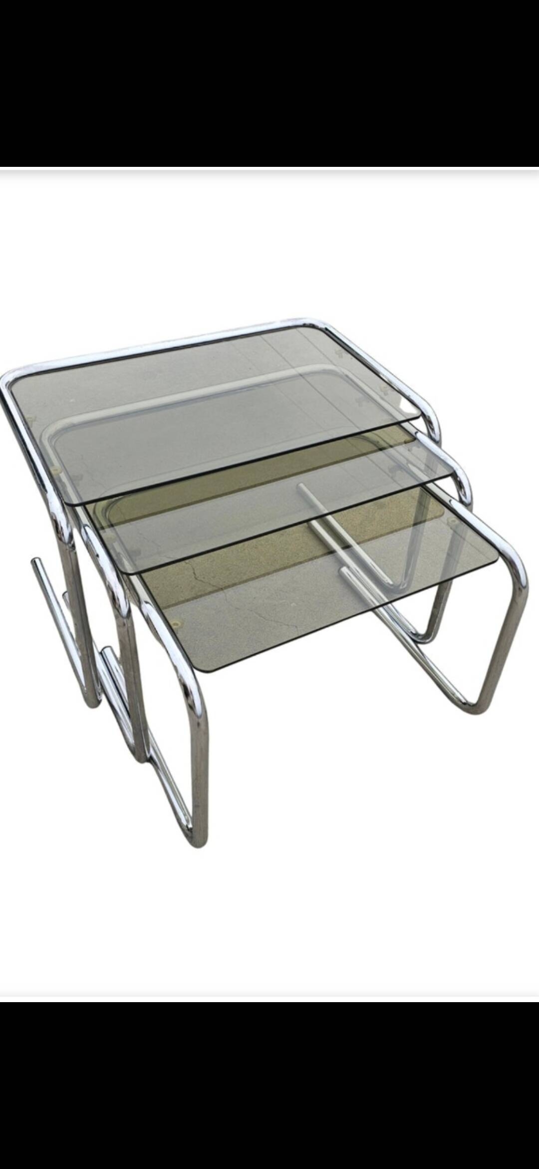 Nest tables in chrome metal and tinted glass.