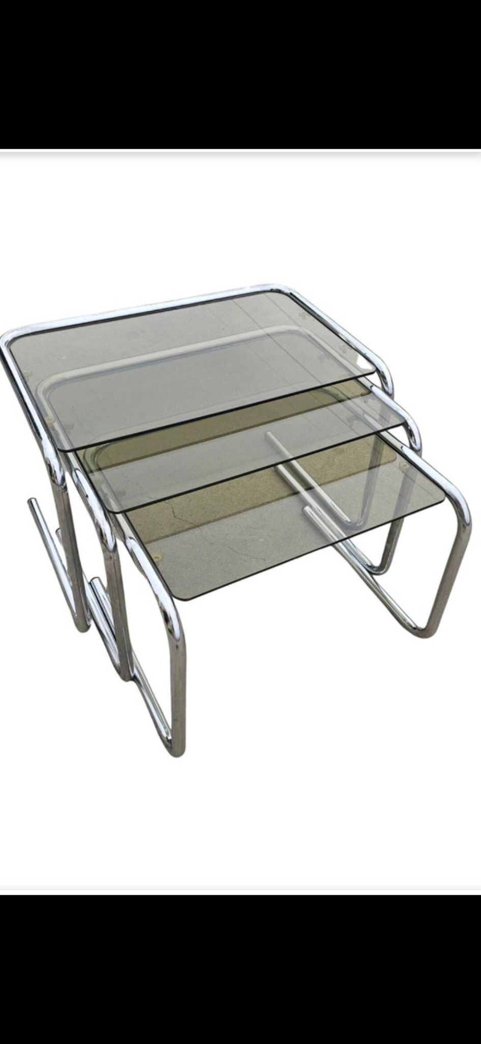 Nest tables in chrome metal and tinted glass.
