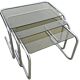 Nest tables in chrome metal and tinted glass.