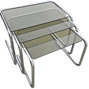 Nest tables in chrome metal and tinted glass.